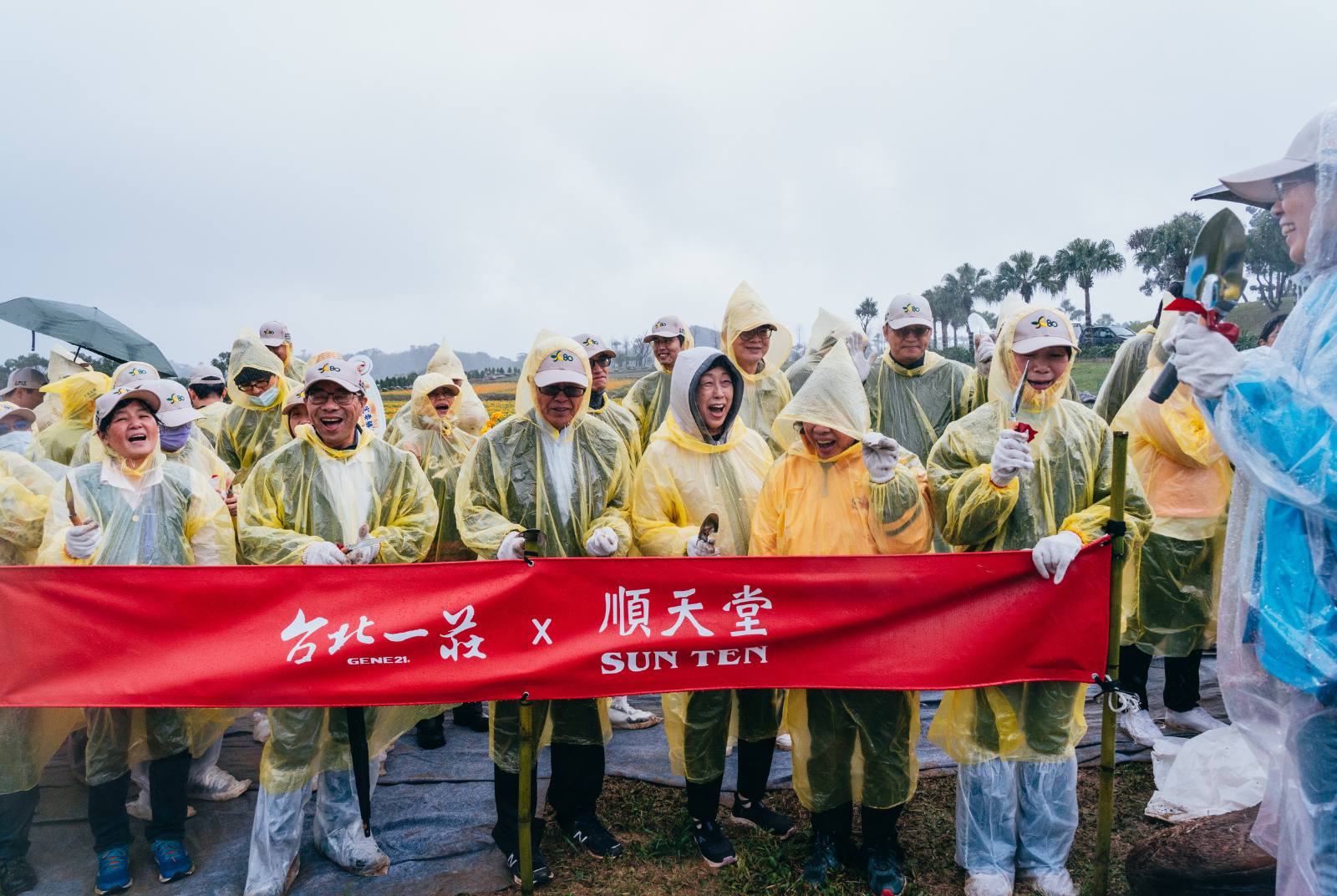 王雪玲副董與同仁雨中植樹，展現燦爛笑容